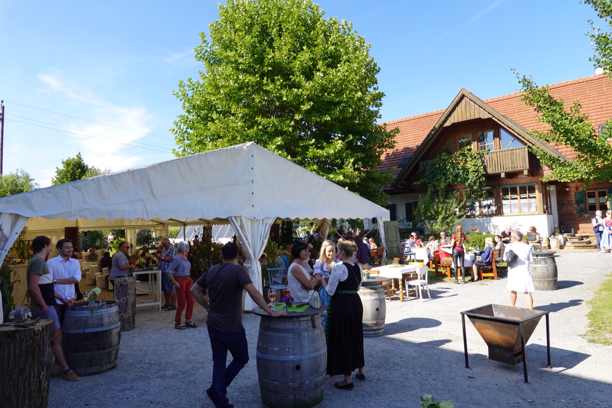 Hoffest am Weingut Resch: Gäste unter Zelt und Bäumen vor dem Hof in Wildbach